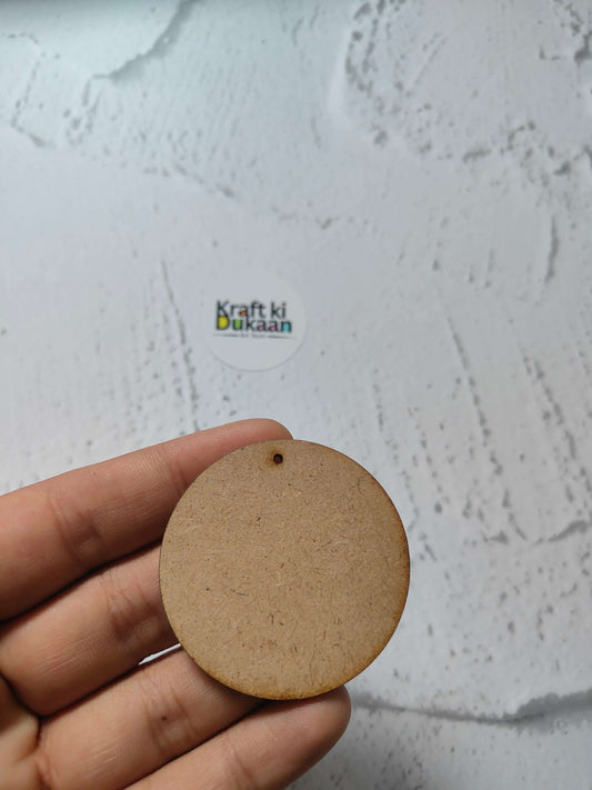 Round MDF craft tag with small top hole, held in fingers, natural brown
