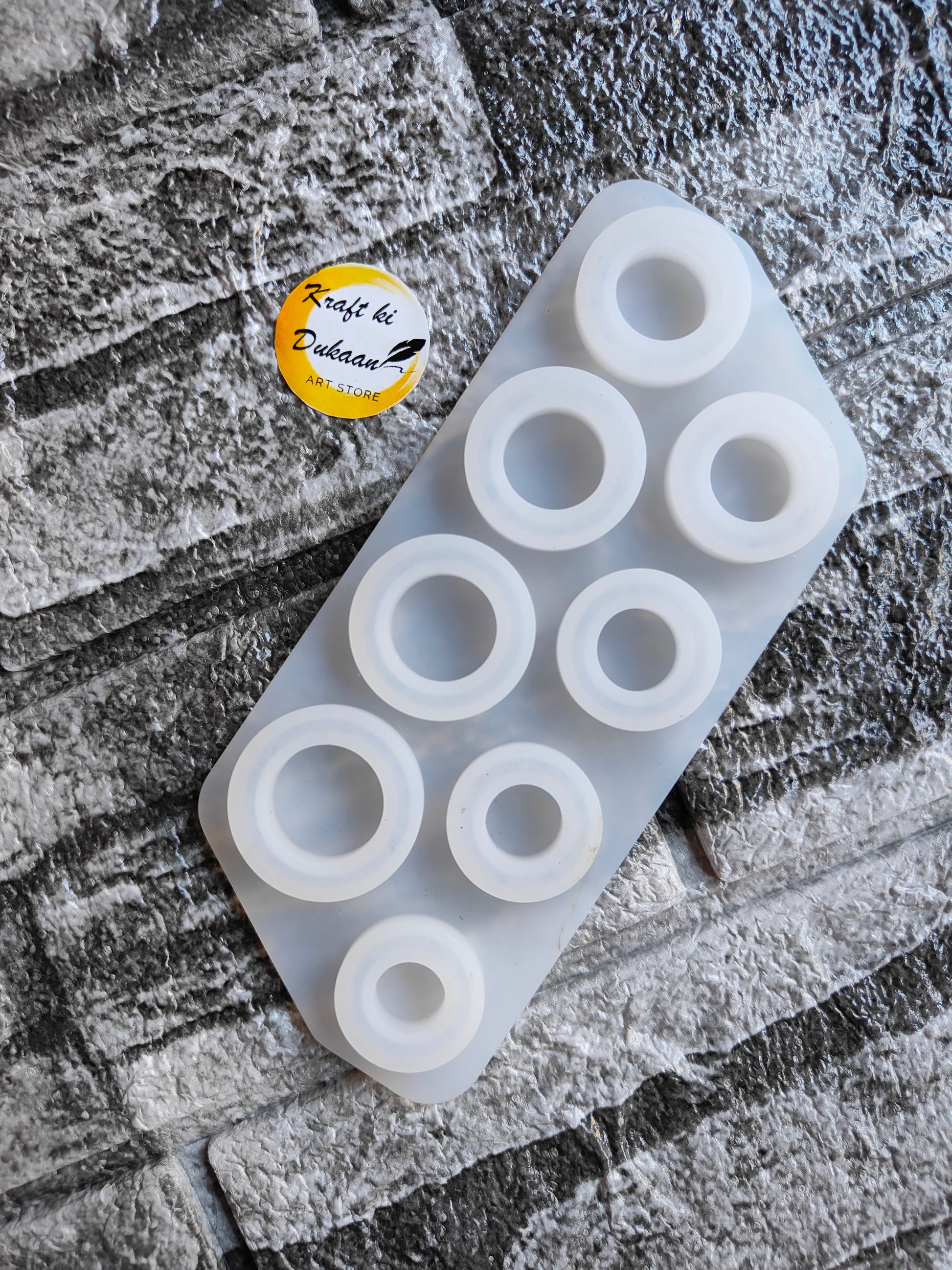 8 cavity ring mold for resin made of white silicone by Kraft ki Dukaan on textured surface