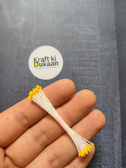 Artificial Pollens 6CM bunch—yellow petals on white stems in hand close-up.