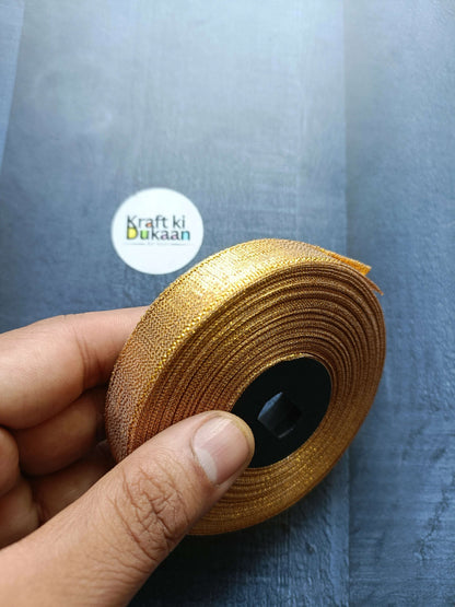 Tissue Ribbon Roll - Golden glitter ribbon roll held in hand