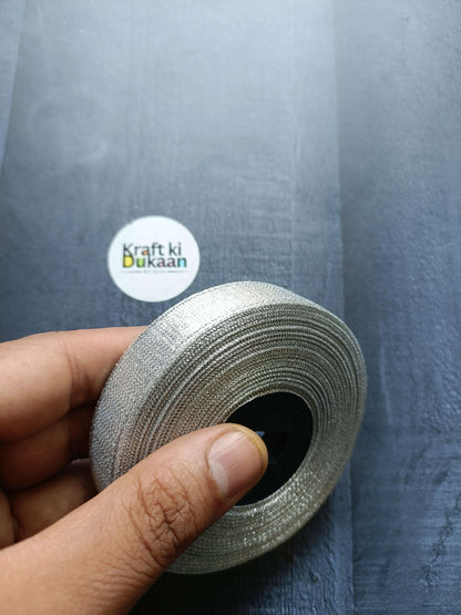 Tissue Ribbon Roll - Silver glitter ribbon roll held in hand
