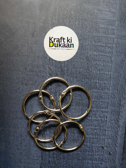 Silver-tone metal book binder rings, overlapping circular loops with hinge rivets