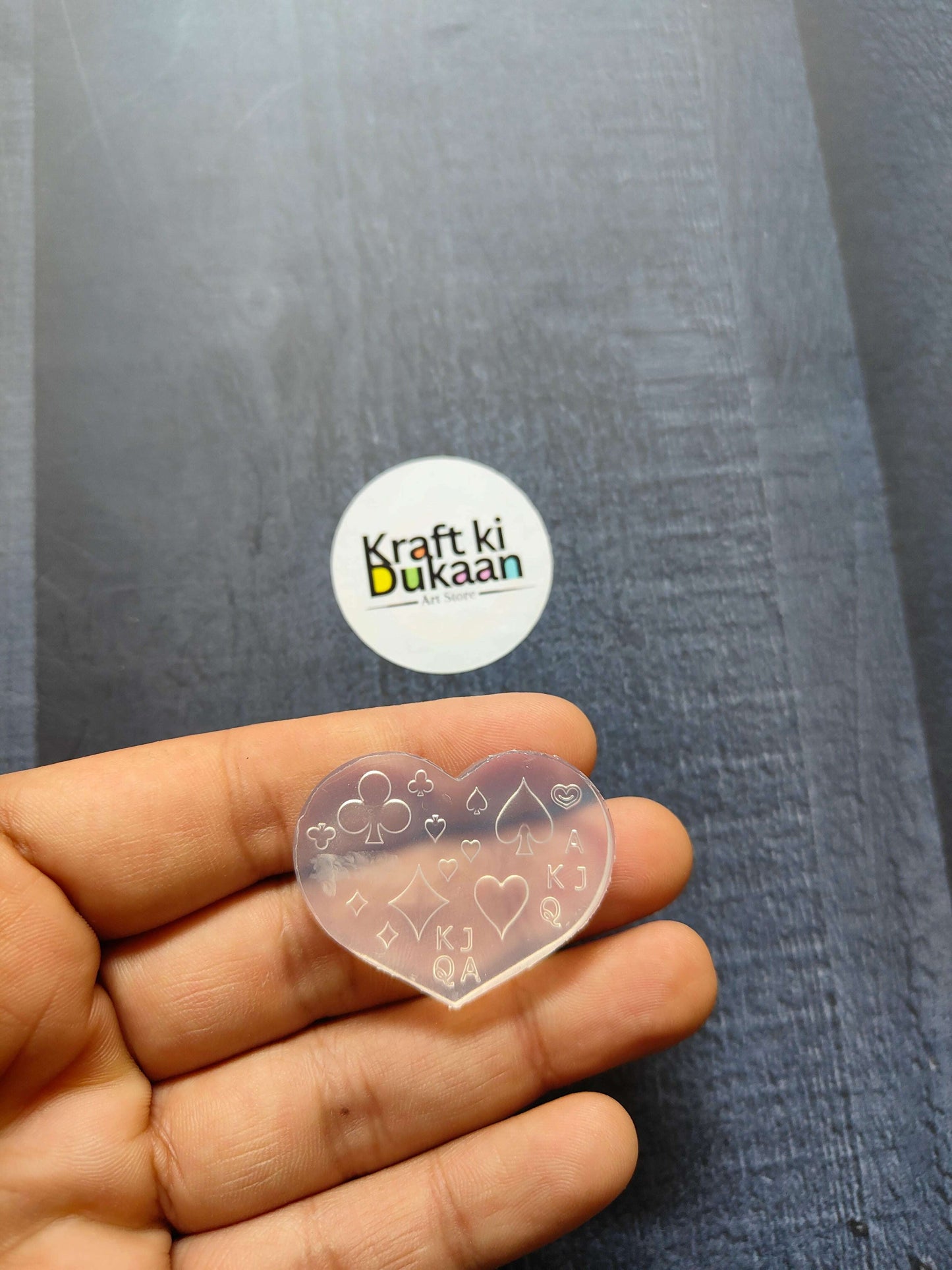 Heart-shaped nail art mould with line icons, held in hand