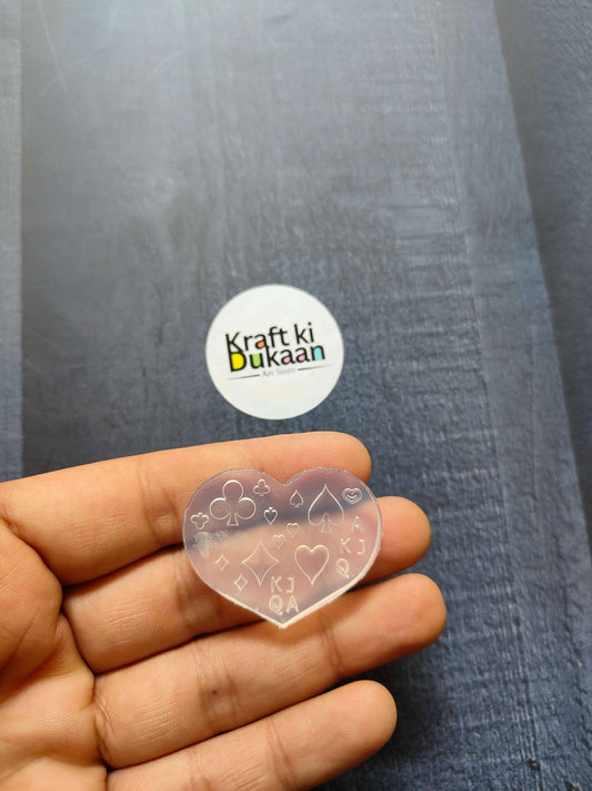 Heart-shaped nail art mould with line icons, held in hand