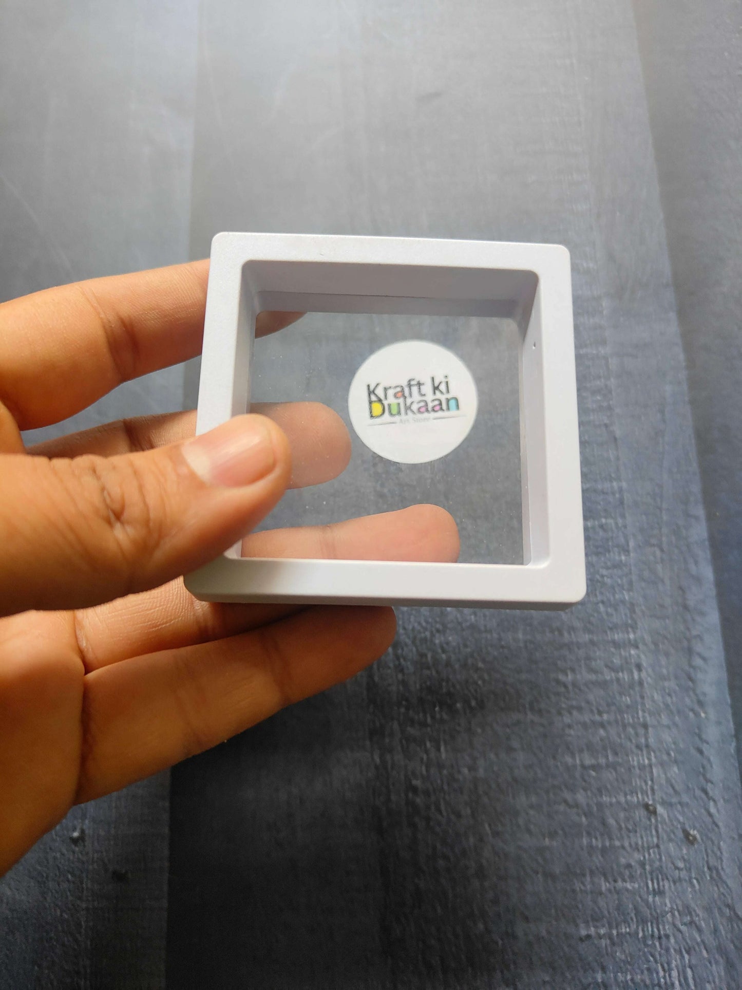 Display Box 7x7cm, white frame with transparent window and “Kraft ki Dukaan” logo