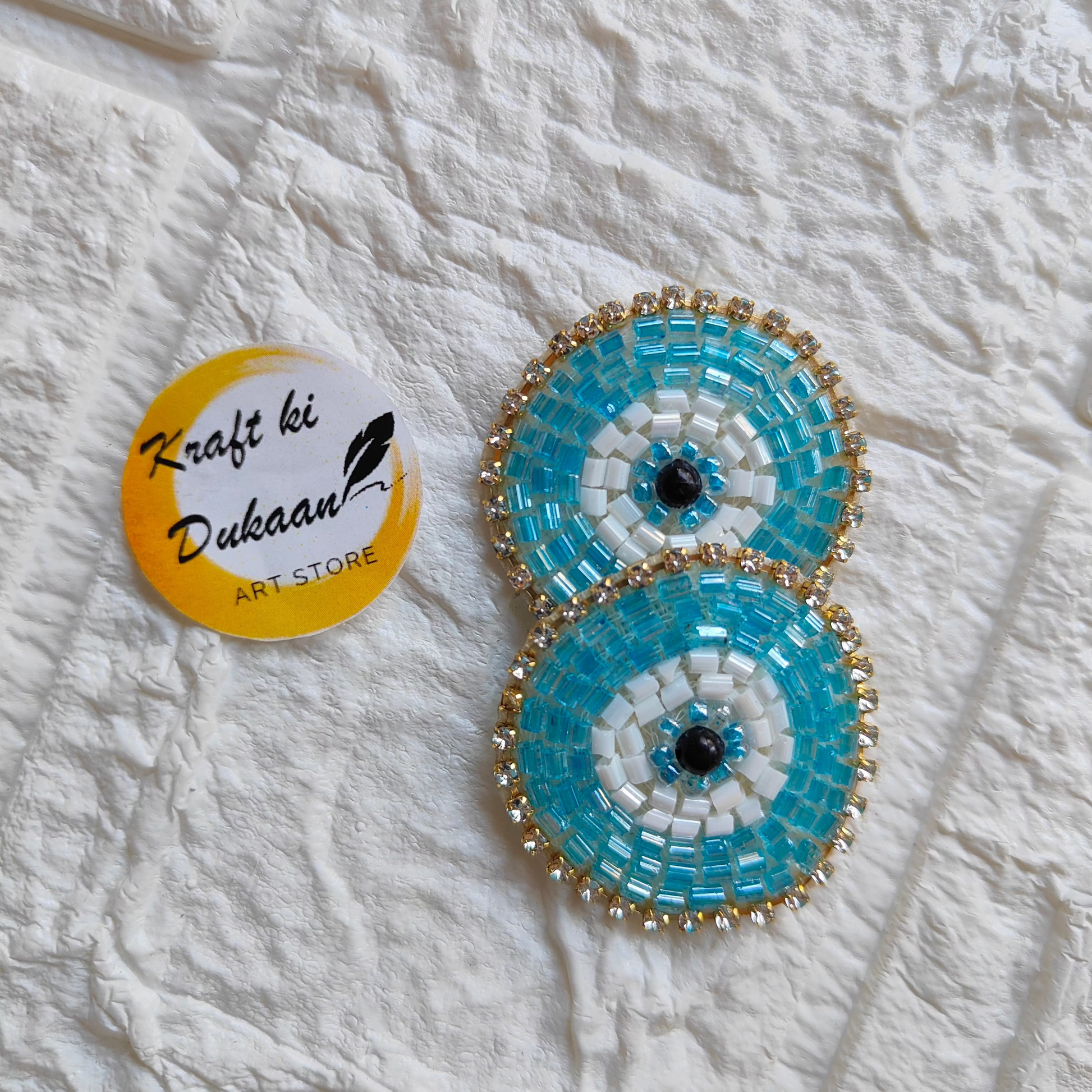 Evil eye embroidered patches in blue and white with golden beads for decorative purposes