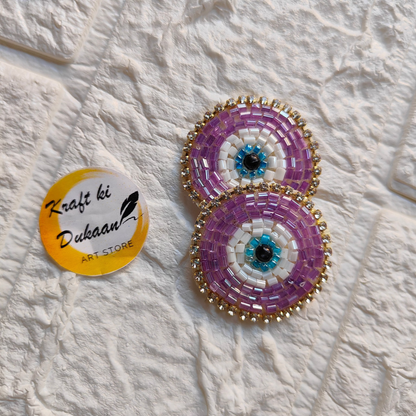Vibrant evil eye embroidered patches with intricate beadwork in purple and blue for decorative use