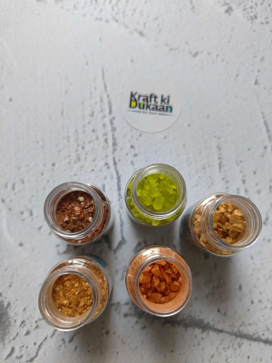 Five jars of assorted glass stone pieces: green, amber, copper and brown tones