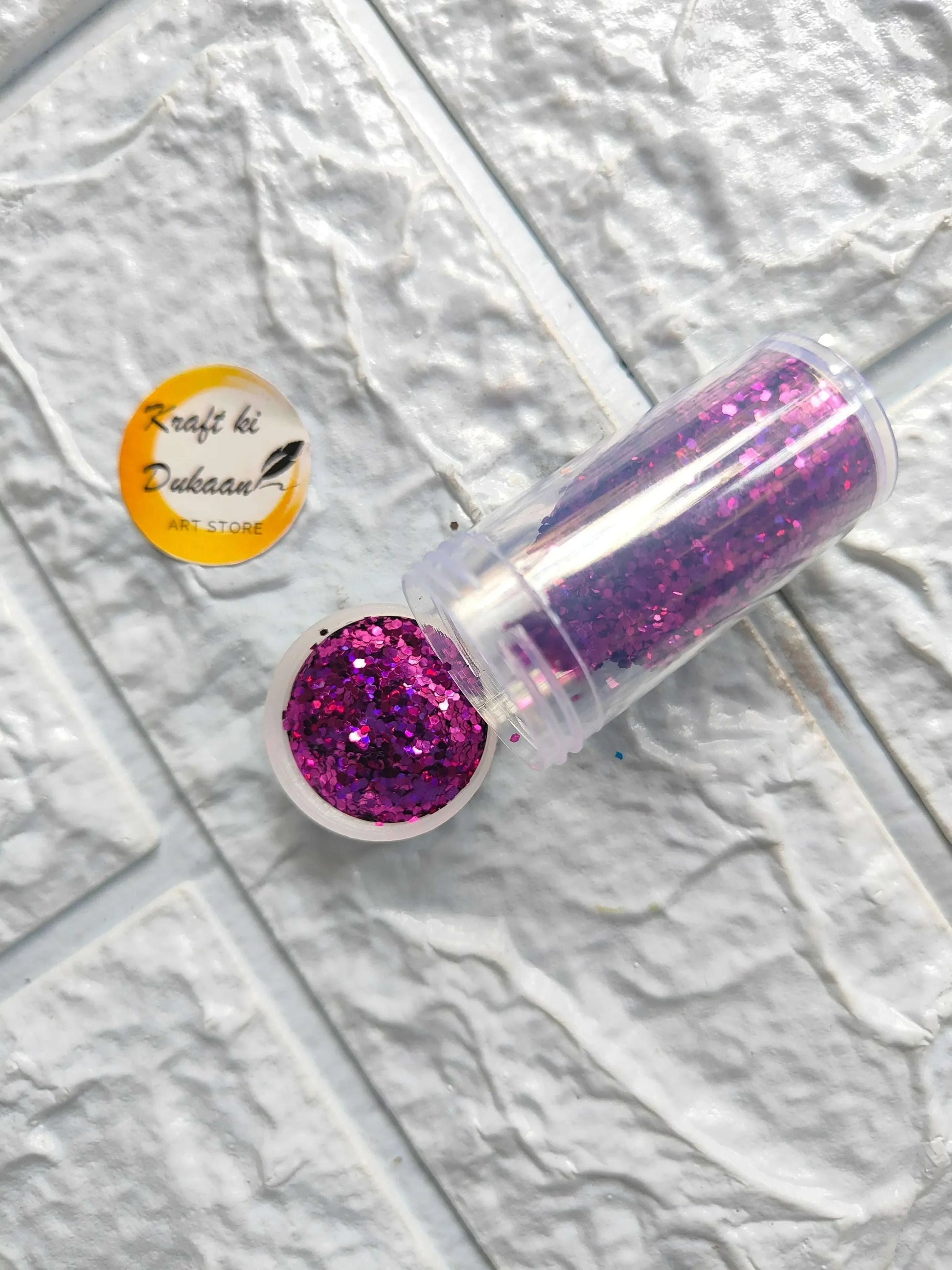 Glitter chunks in clear tube with magenta sparkle pieces.
