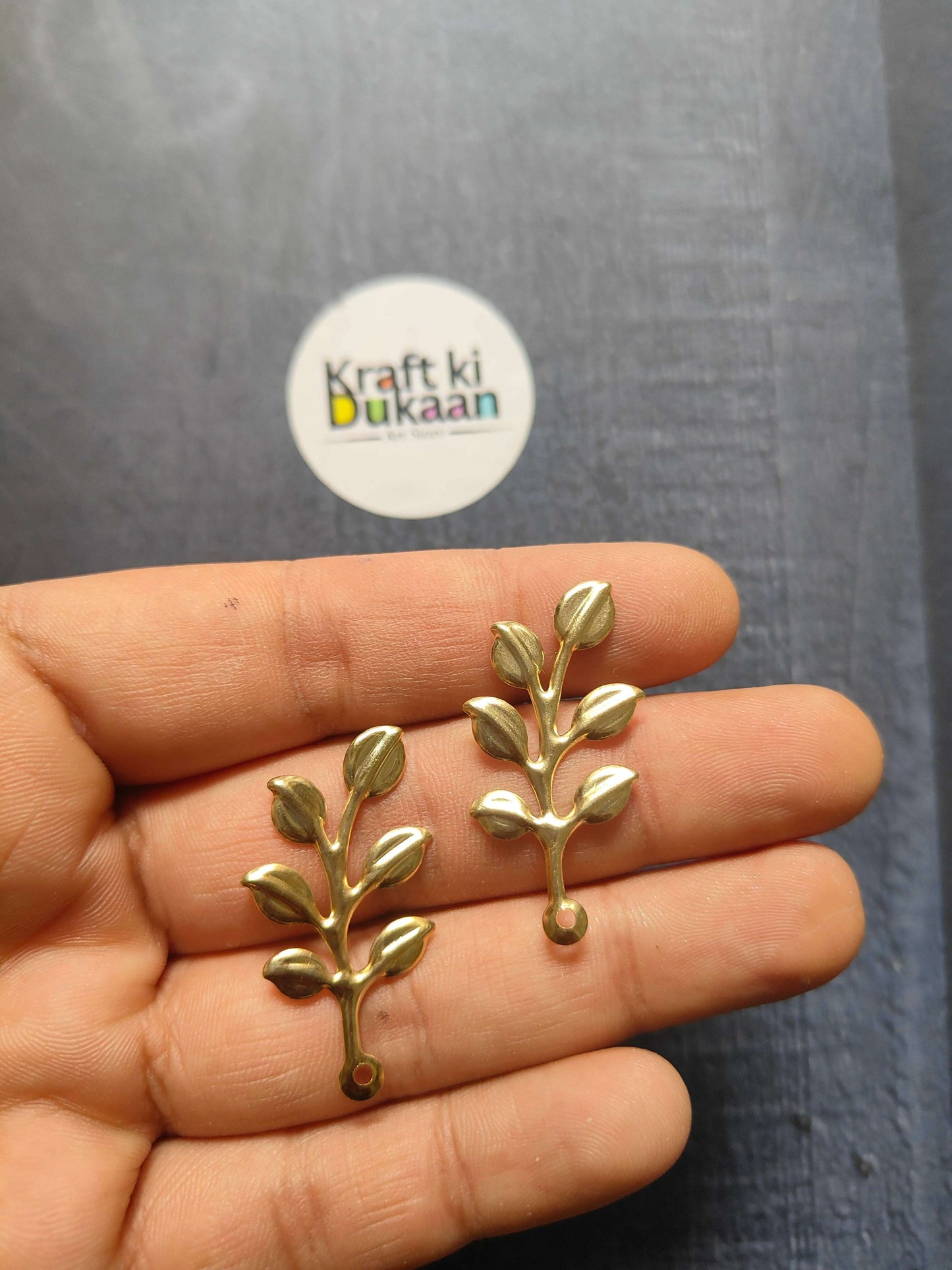 Metal leaf A17 set of small gold sprigs with oval leaves, held in hand