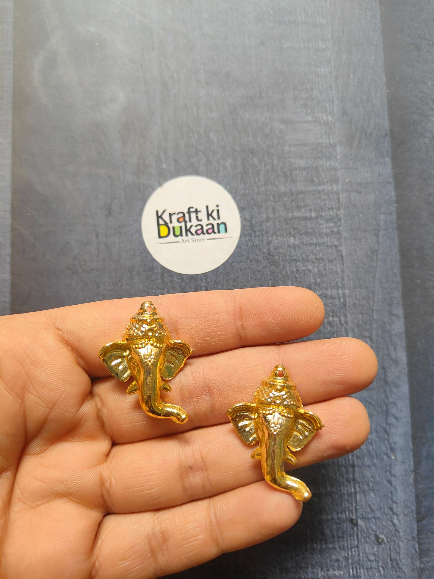 Golden Ganpati face charm, 3.5cm; two figurines held in hand