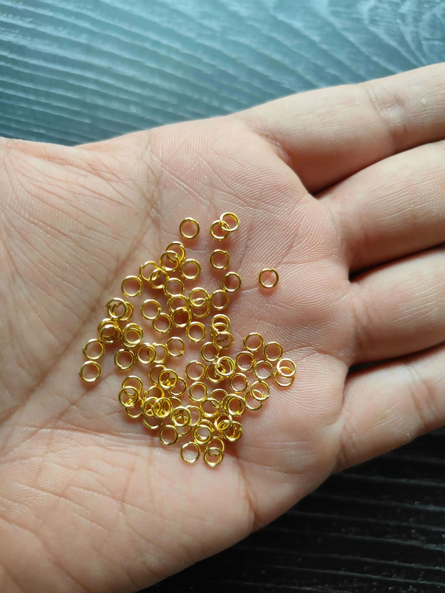 Kraft ki Dukaan Golden Circle metal rings—gold-tone loops on palm, many pieces