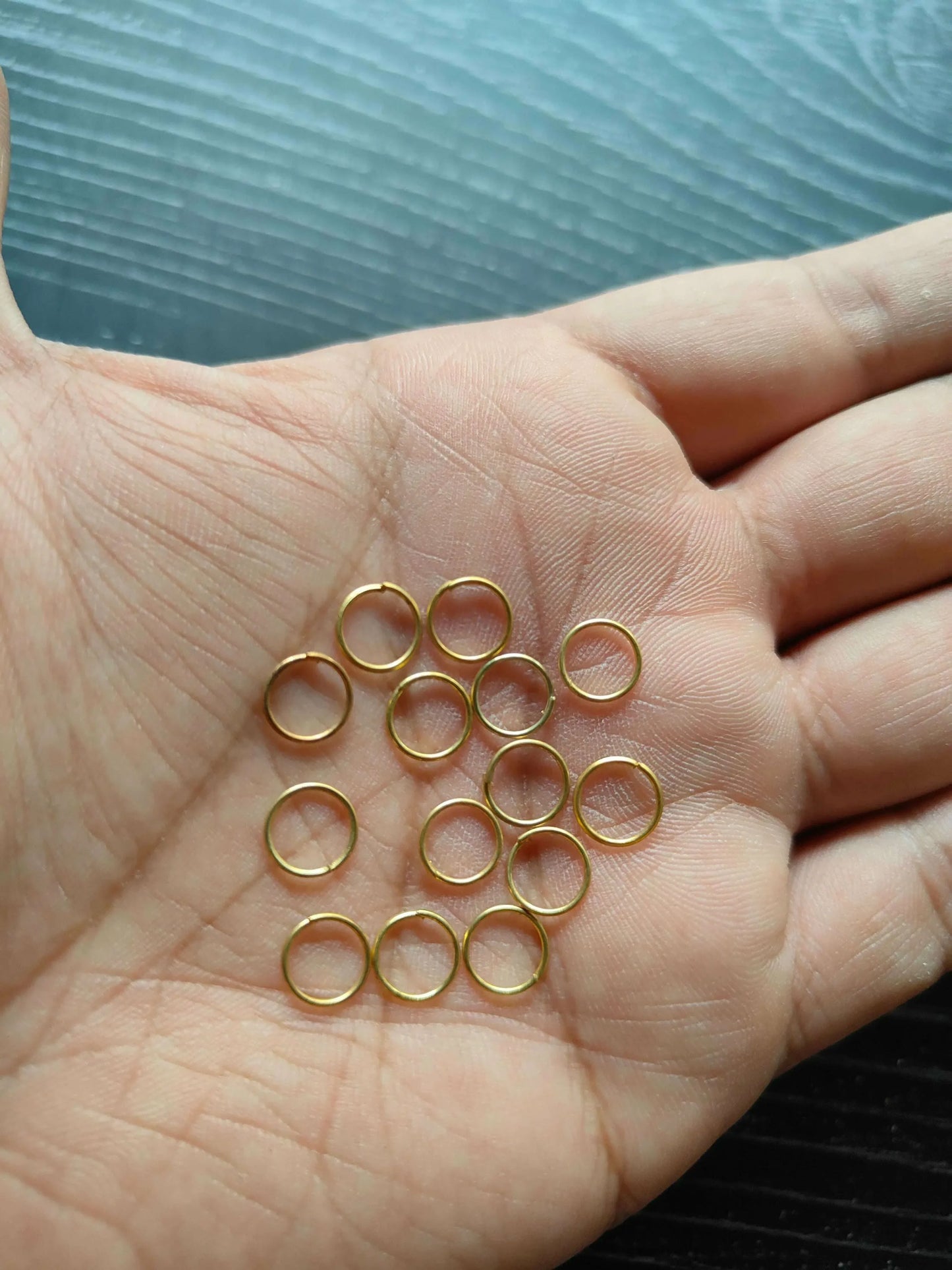 Golden Circle metal rings, gold-tone circular loops on palm in a smaller cluster