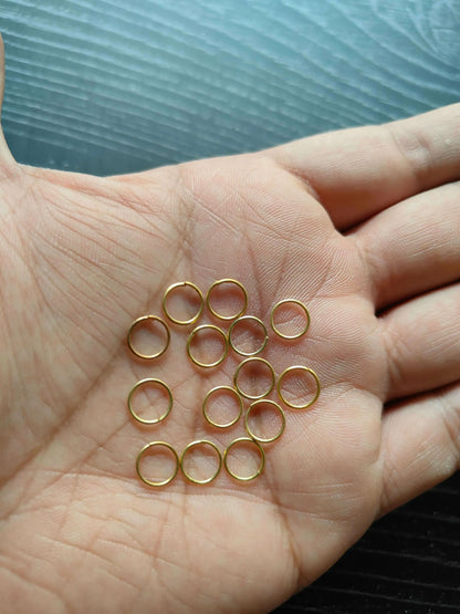 Golden Circle metal rings, gold-tone circular loops on palm in a smaller cluster