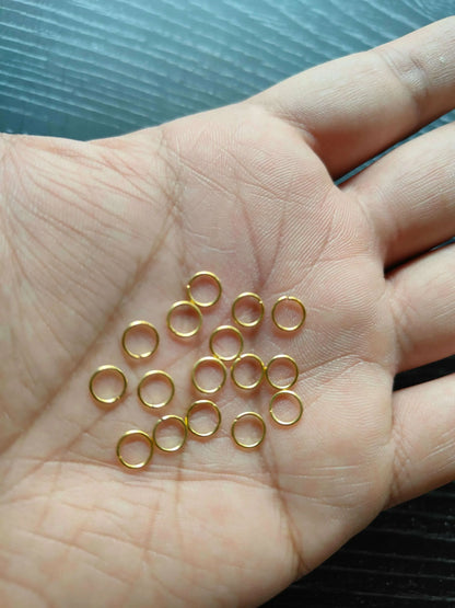 Golden Circle metal rings with small gold-tone loops scattered on palm