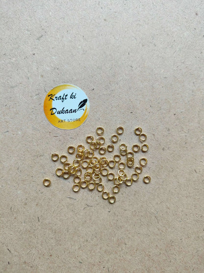 Many small golden metal ring loops with open centers, mixed arrangement