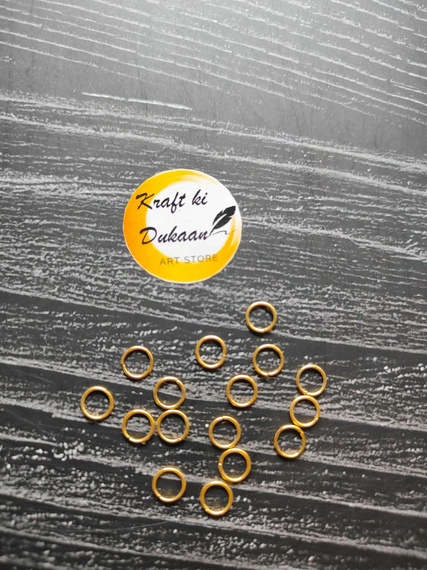 Small golden metal rings, round hoops with open centers, spread out