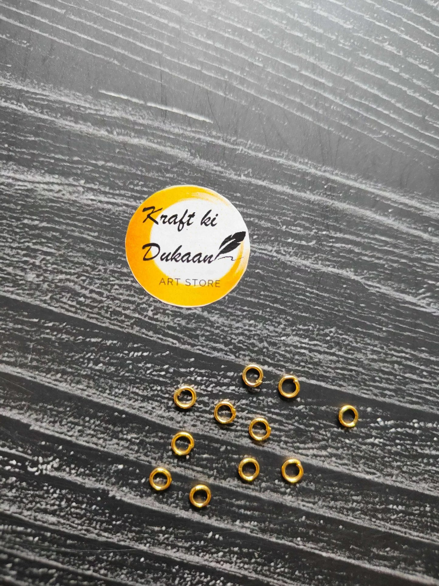 Small golden metal round rings, open center, scattered on surface
