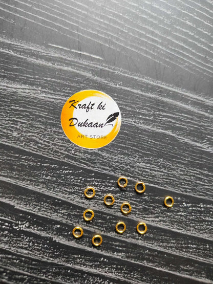 Small golden metal round rings, open center, scattered on surface