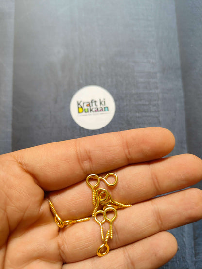Gold eye screw hooks, looped eyes on screw shanks (close-up in hand)