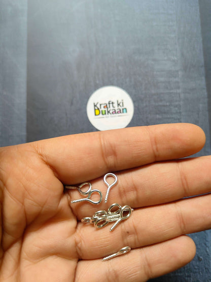 Silver eye screw hooks, looped eyes on screw shanks (close-up in hand)