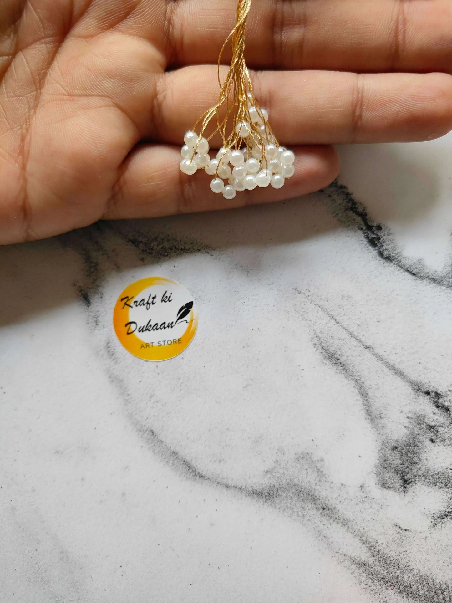 Latkan A9 close-up: gold cord with pearl bead drops