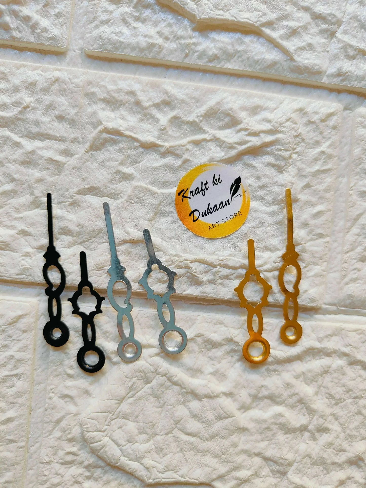 Clock hands A32: black and gold metal pieces on wall