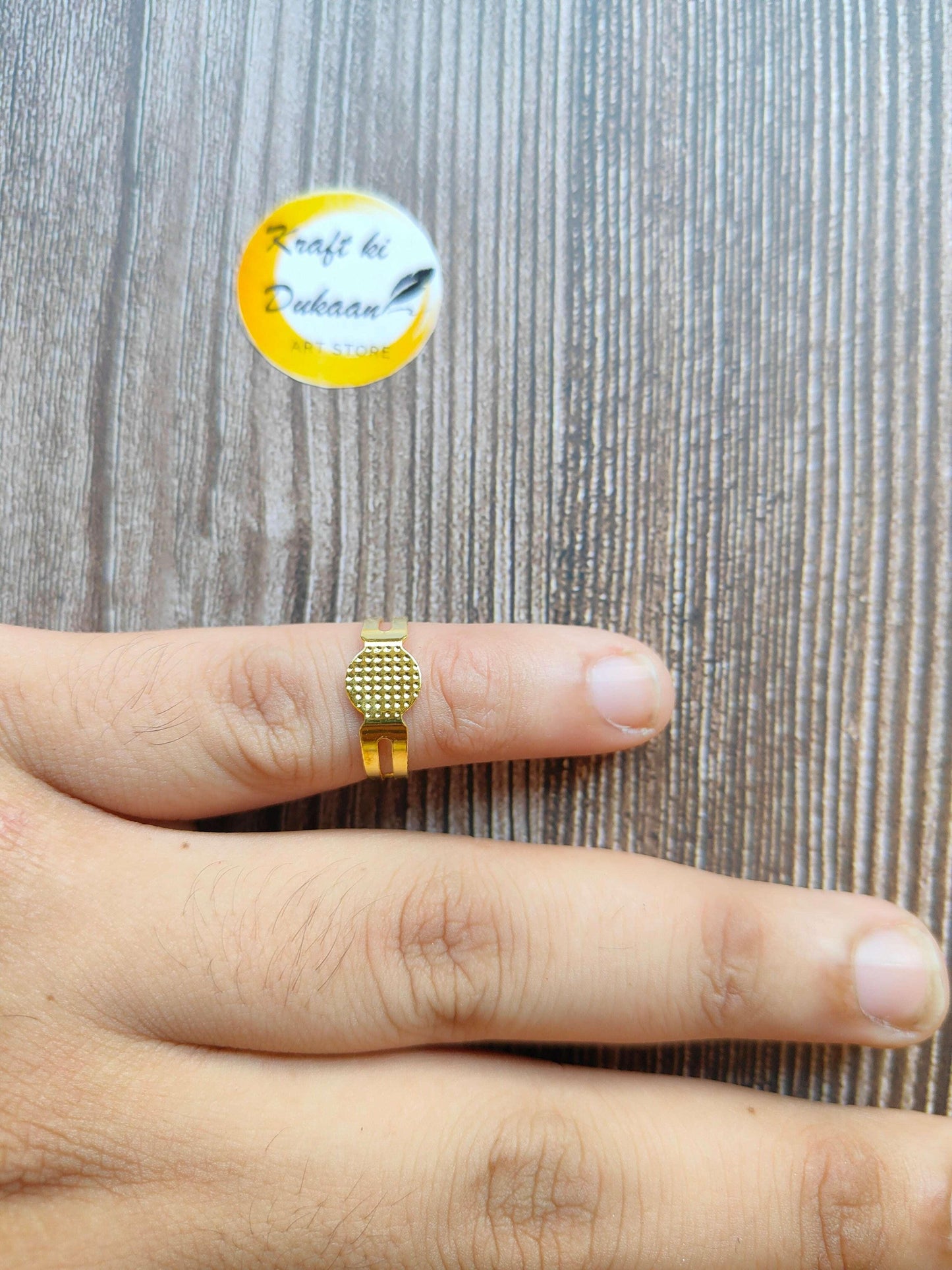 Single gold-tone metal ring base with textured square top