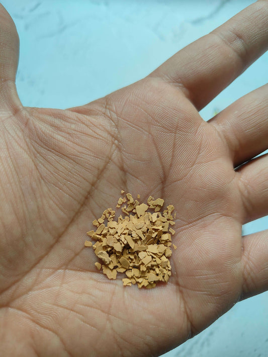 Gold rock stone chips in hand, loose flake pieces