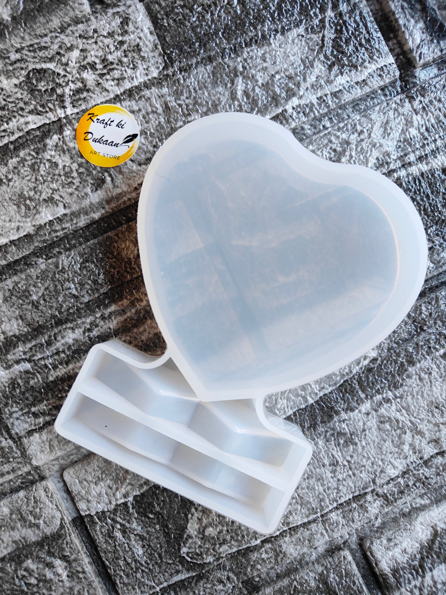 Heart shaped resin frame mould from Kraft ki Dukaan on textured surface for crafting projects