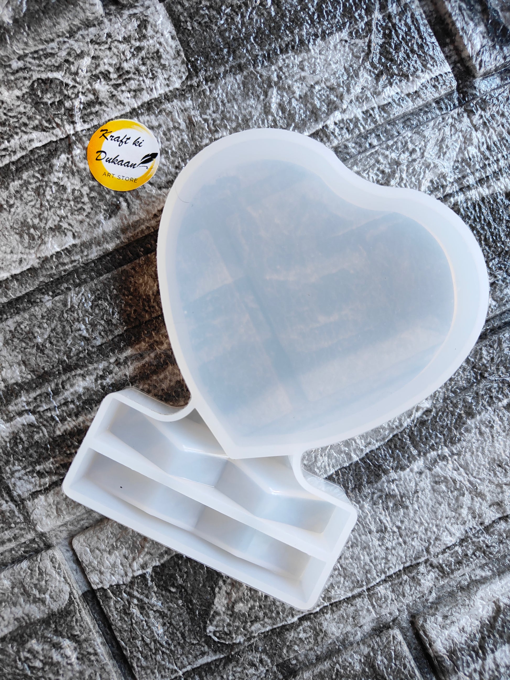 Heart shaped resin frame mould from Kraft ki Dukaan on textured surface for crafting projects