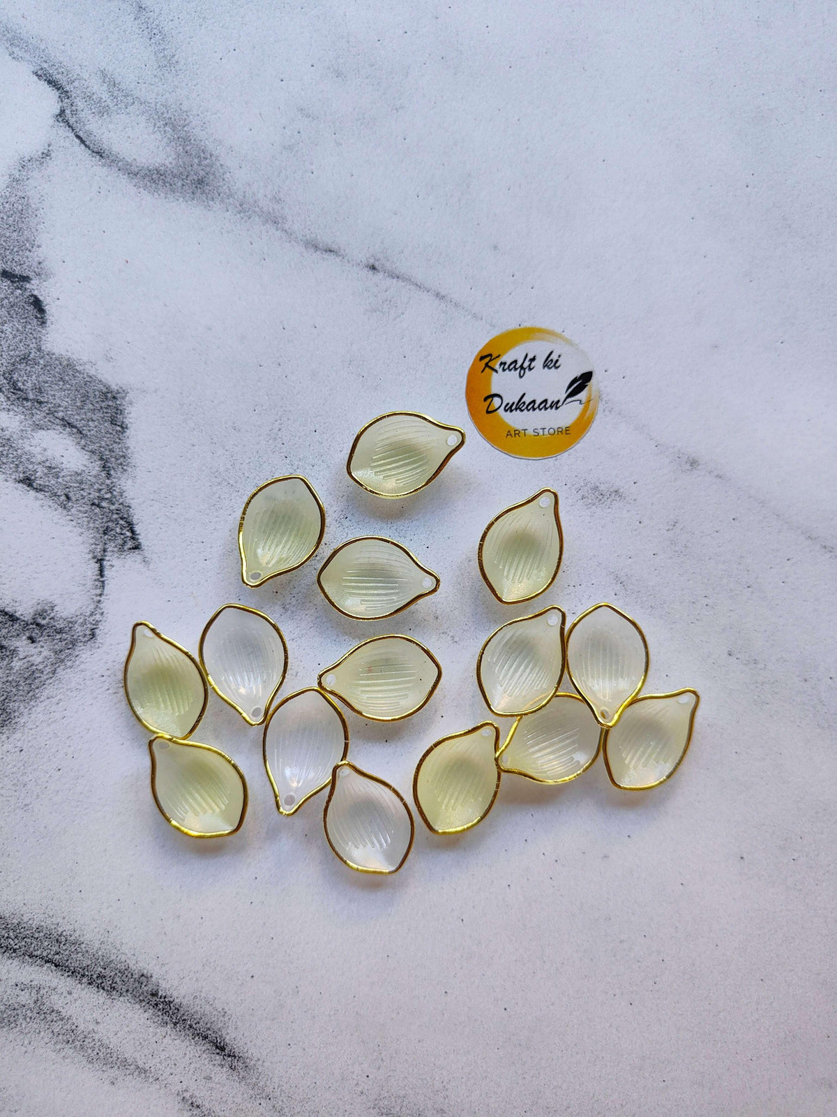 Acrylic petal beads in pale yellow/cream tones, gold-edged teardrop petals