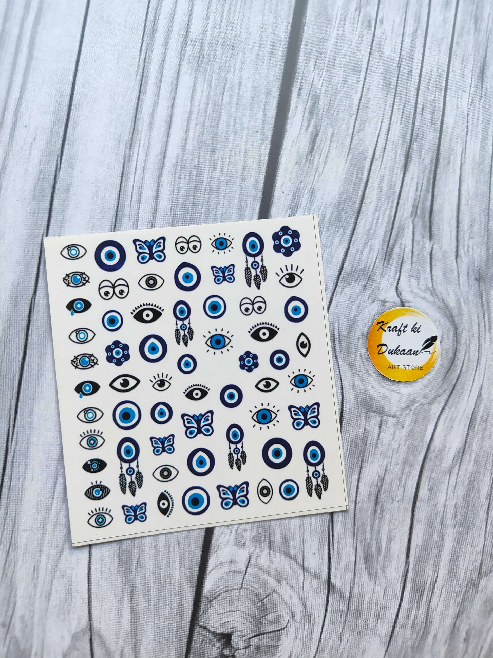 Colorful mini sticker sheet for keychains featuring eyes and butterflies in blue and black designs