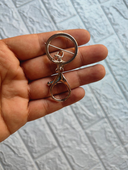 Hand holding a shiny lobster clasp keychain with a ring attachment for easy key organization