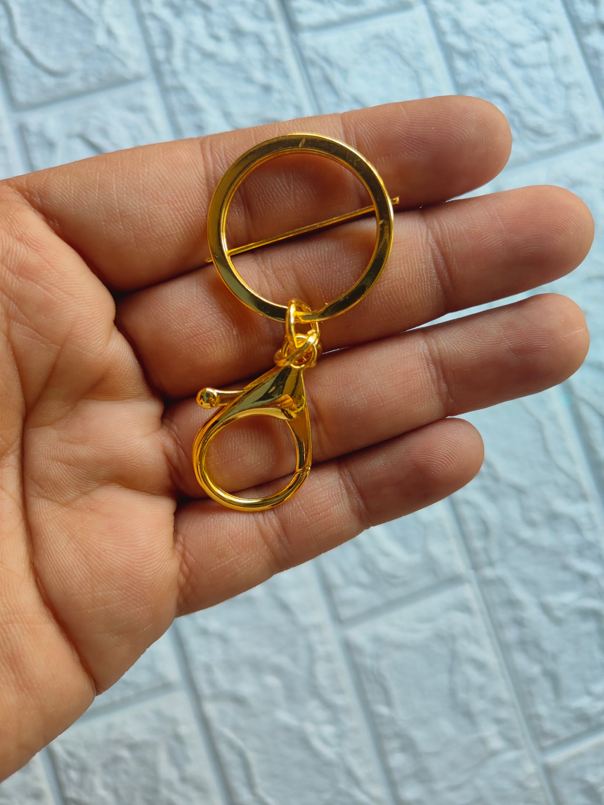 Gold lobster clasp keychain held in a hand, ideal for attaching keys or accessories