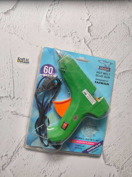 Hot melt glue gun blister pack, green body with orange front and black power cord.