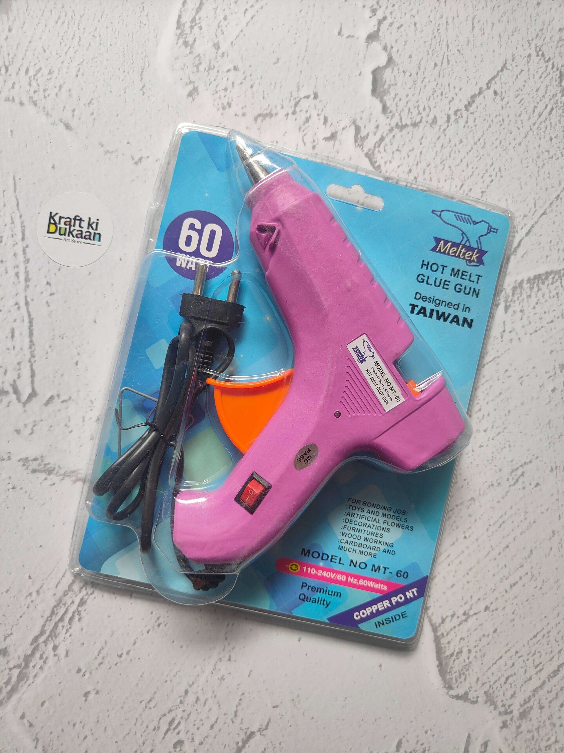 Hot melt glue gun blister pack, pink body with orange front and black power cord.