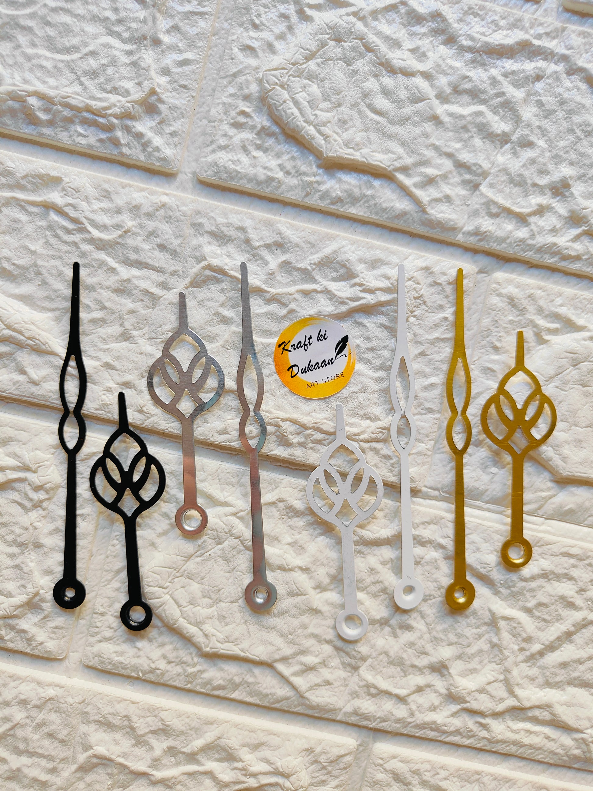 Set of metal clock hands for crafts in black, gold, silver, and white for DIY projects