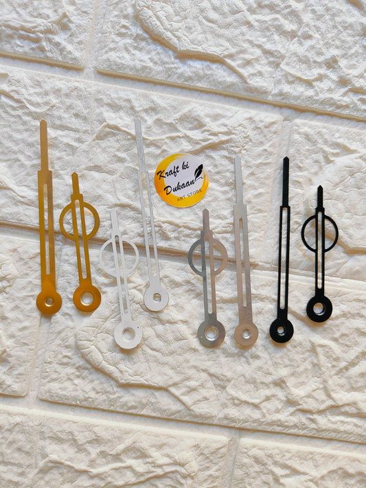 Collection of metal clock hands for crafts in gold, silver, and black colors on a textured background