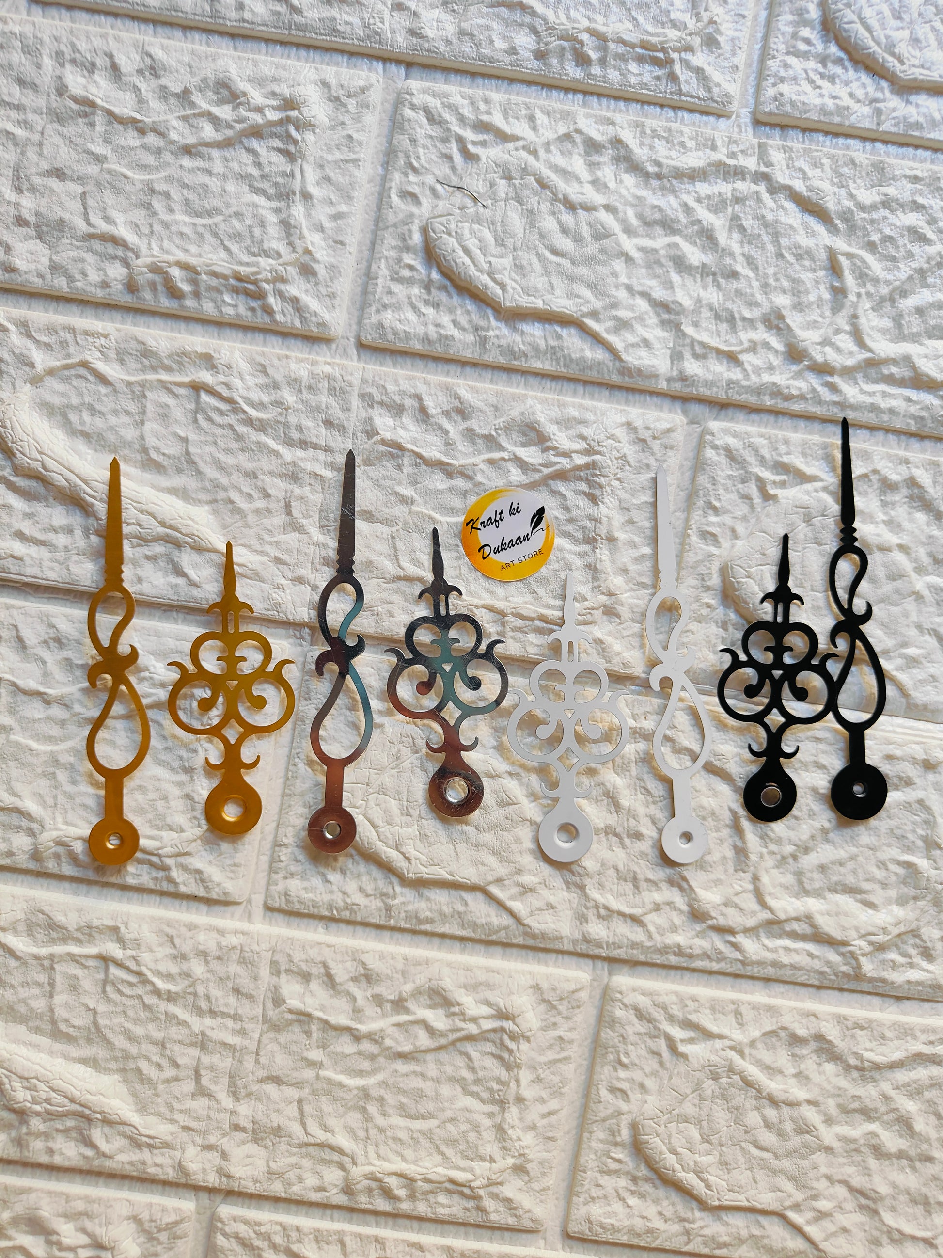 Set of metal clock hands for crafts in various colors including gold, silver, and black