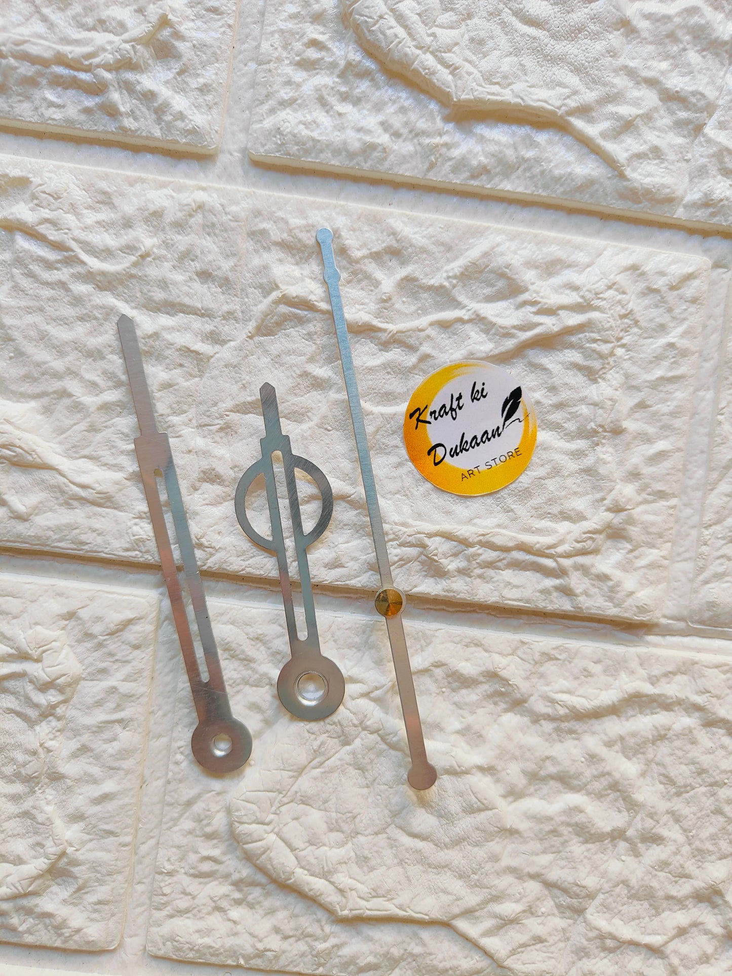 Metal clock hands for crafts displayed against a textured background with Kraft ki Dukaan logo