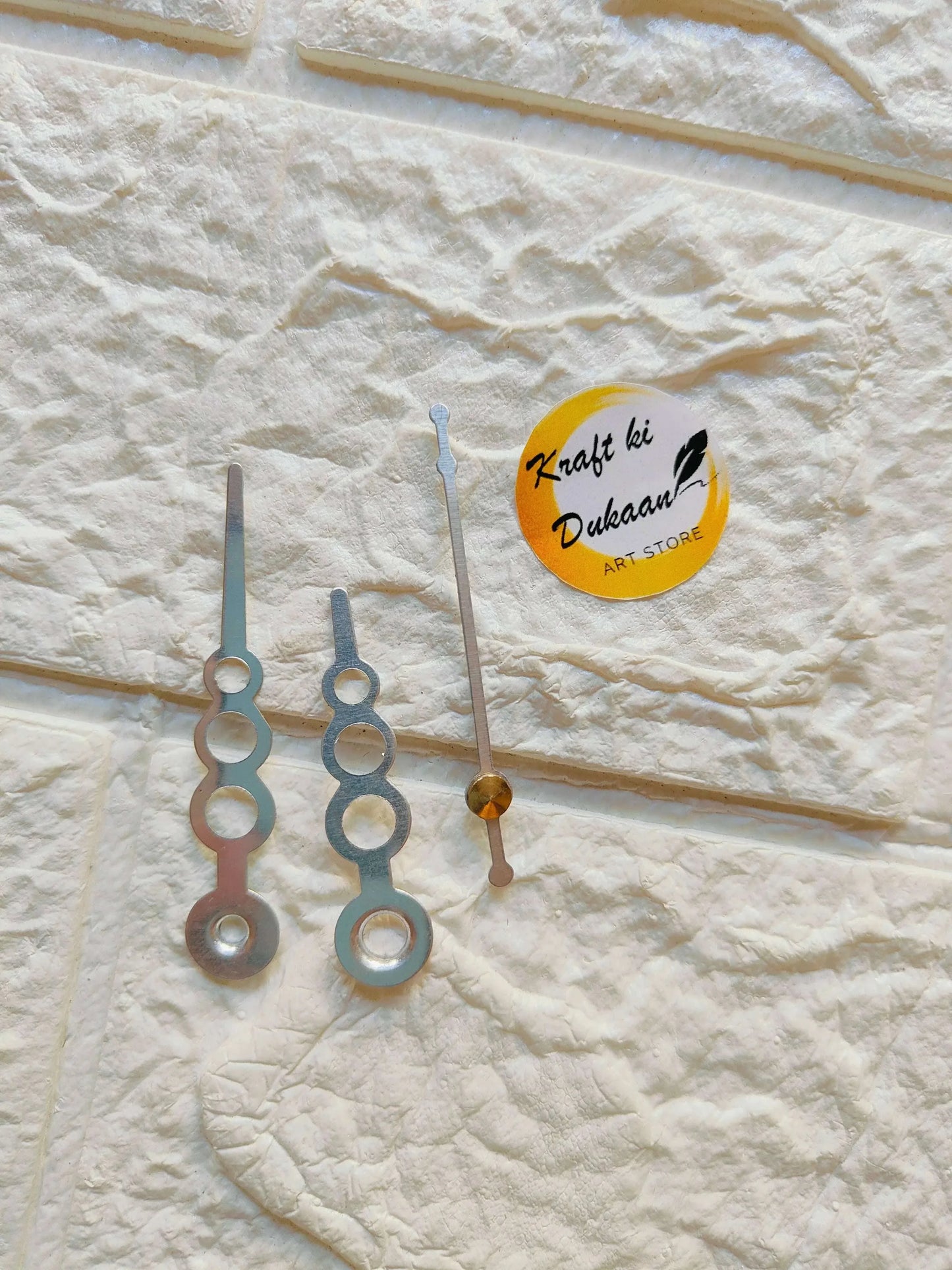 Metal clock hands set with ornate circular tips, blue and gold
