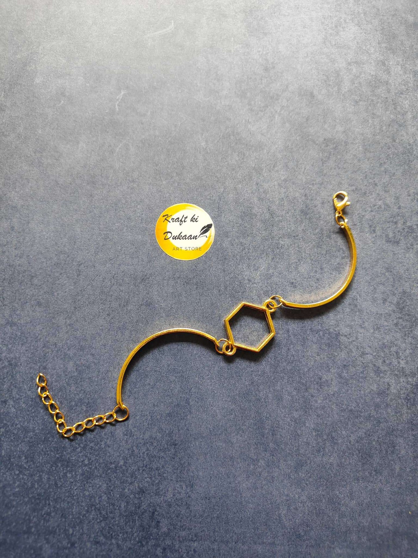 Gold metal bracelet with hexagon charm links and adjustable chain