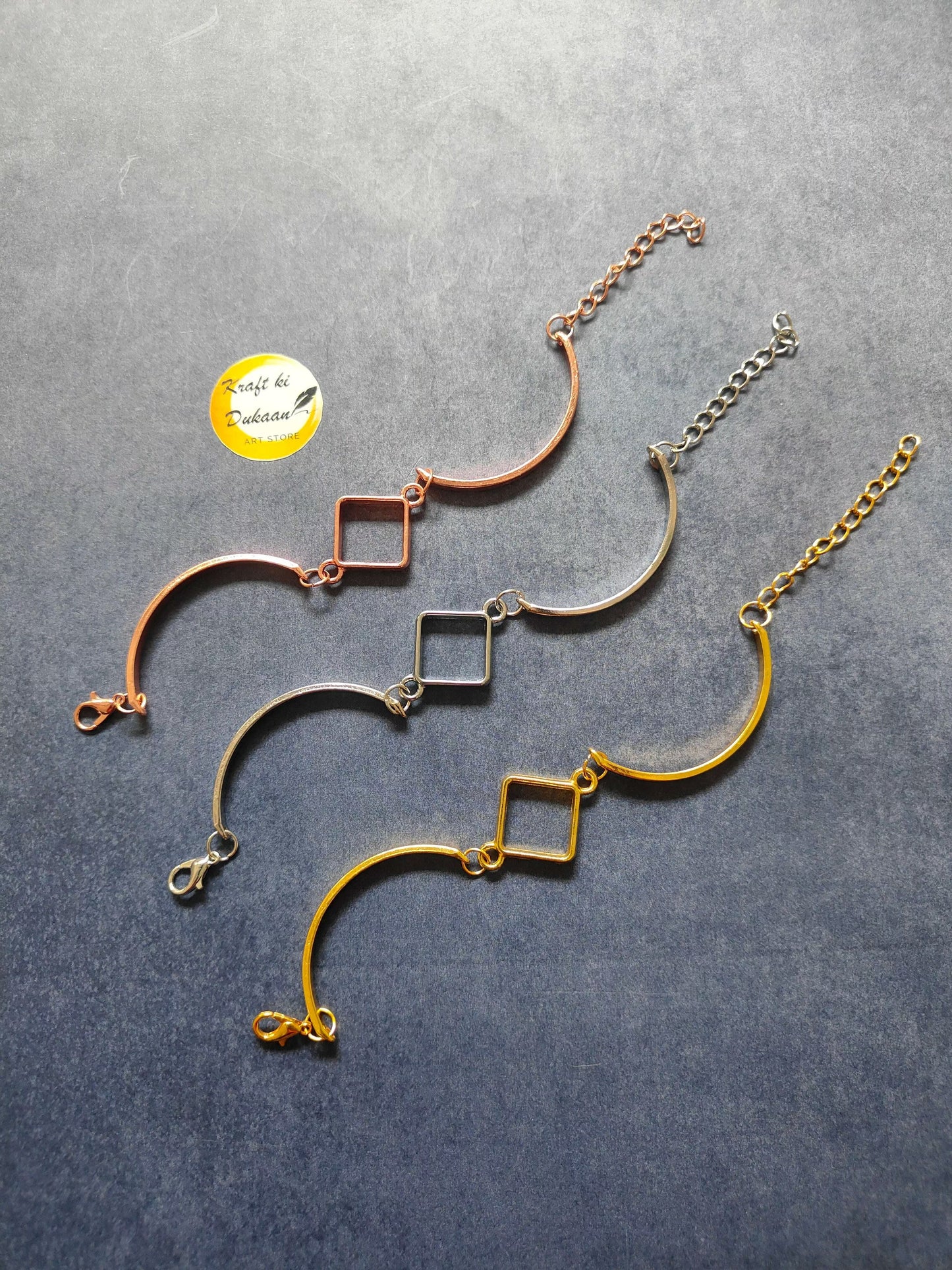 Rose gold metal bracelet with curved bar and square link charms, chain with clasp