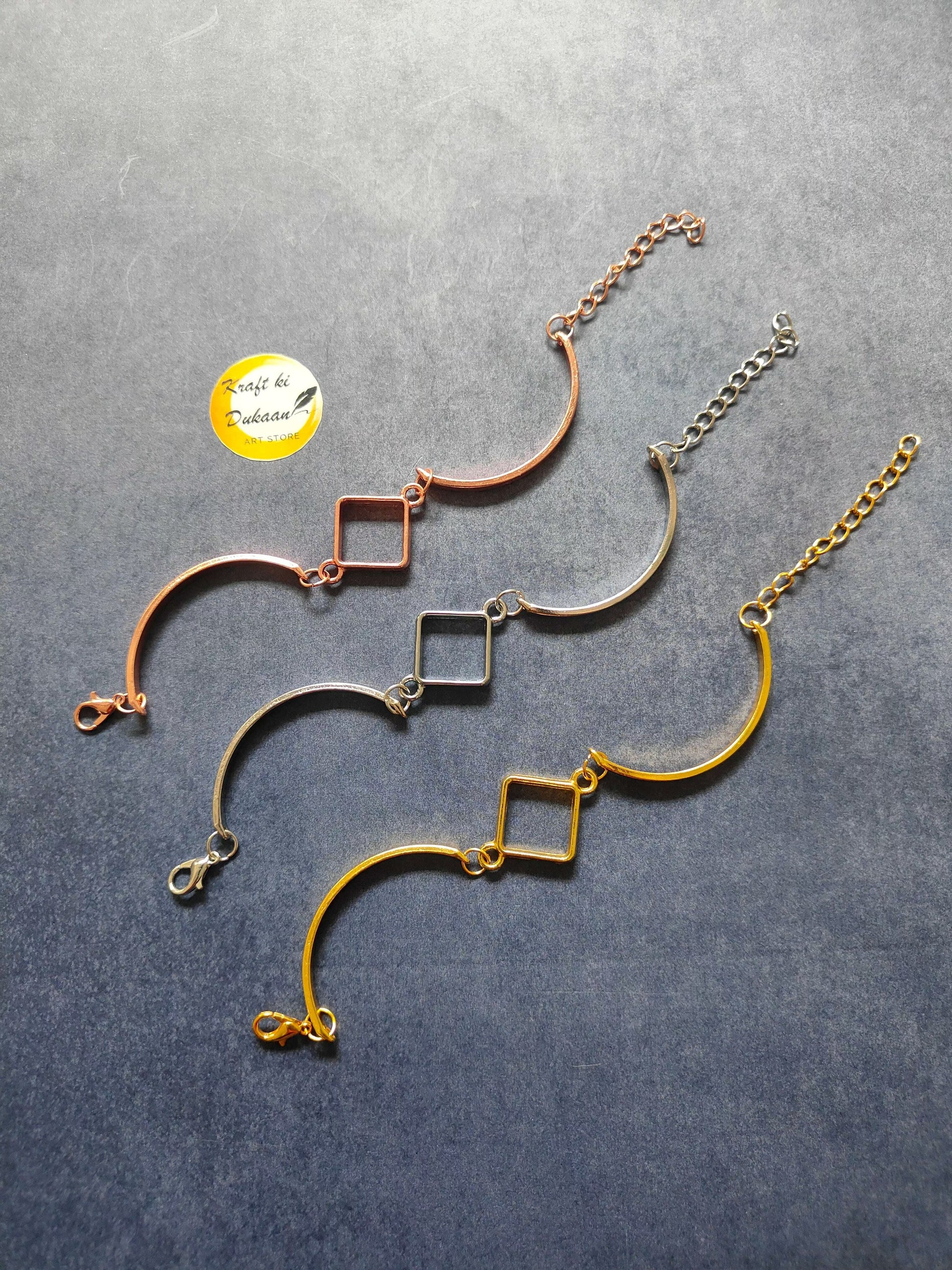 Rose gold metal bracelet with curved bar and square link charms, chain with clasp