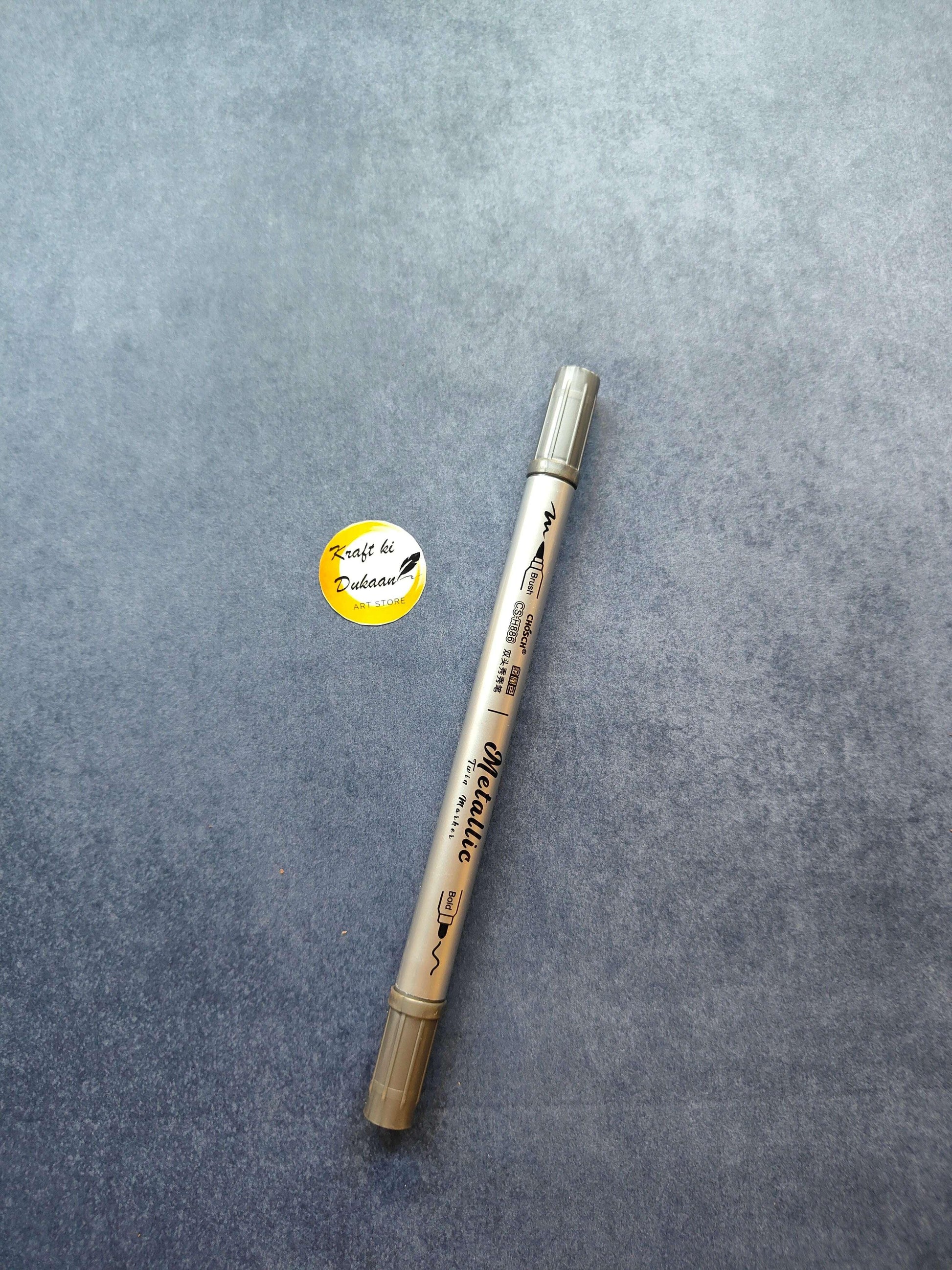 Silver metallic twin-tip marker with cap on one end