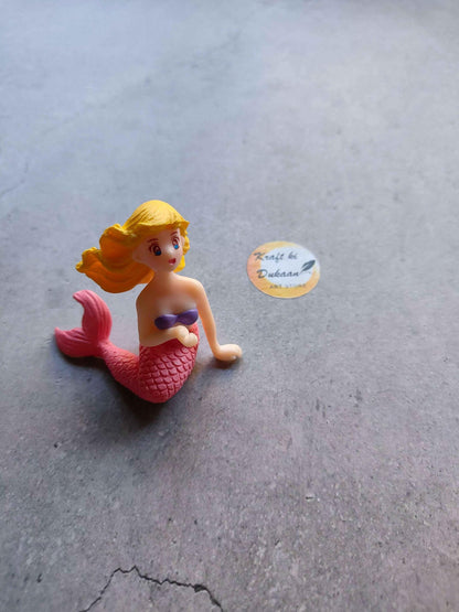 Mini mermaid figurine with red tail and blonde hair, seated pose