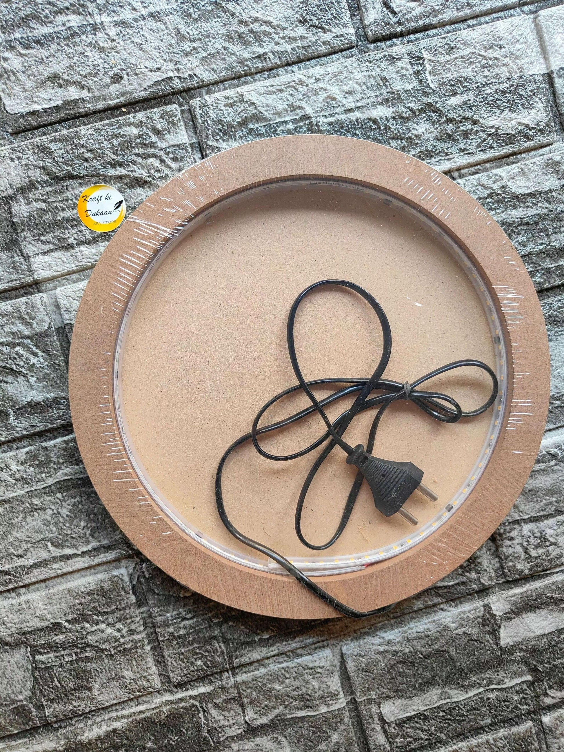 Moon LED lamp board with black power cord and plug on clear ring inside MDF frame