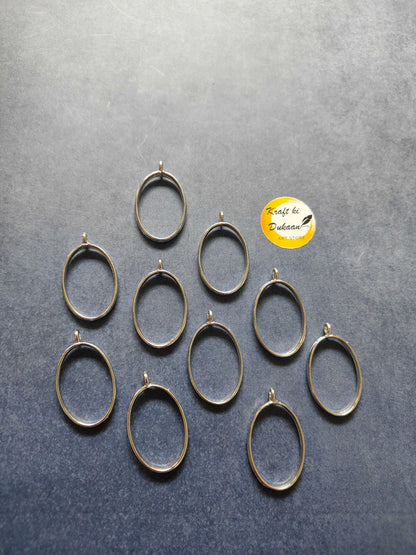 Gold-tone oval bezel pendant frames, 10-piece set laid out with top loops