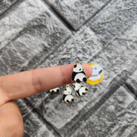 Single panda metal charm with black-and-white enamel and gold hanging loop in hand